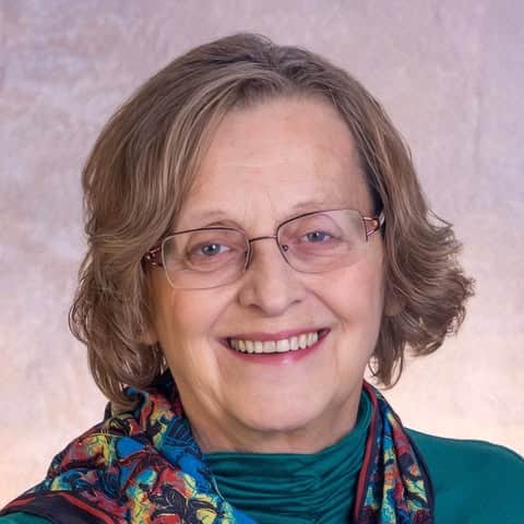 Smiling woman with glasses and colorful scarf promoting Hands Off! Haywood.